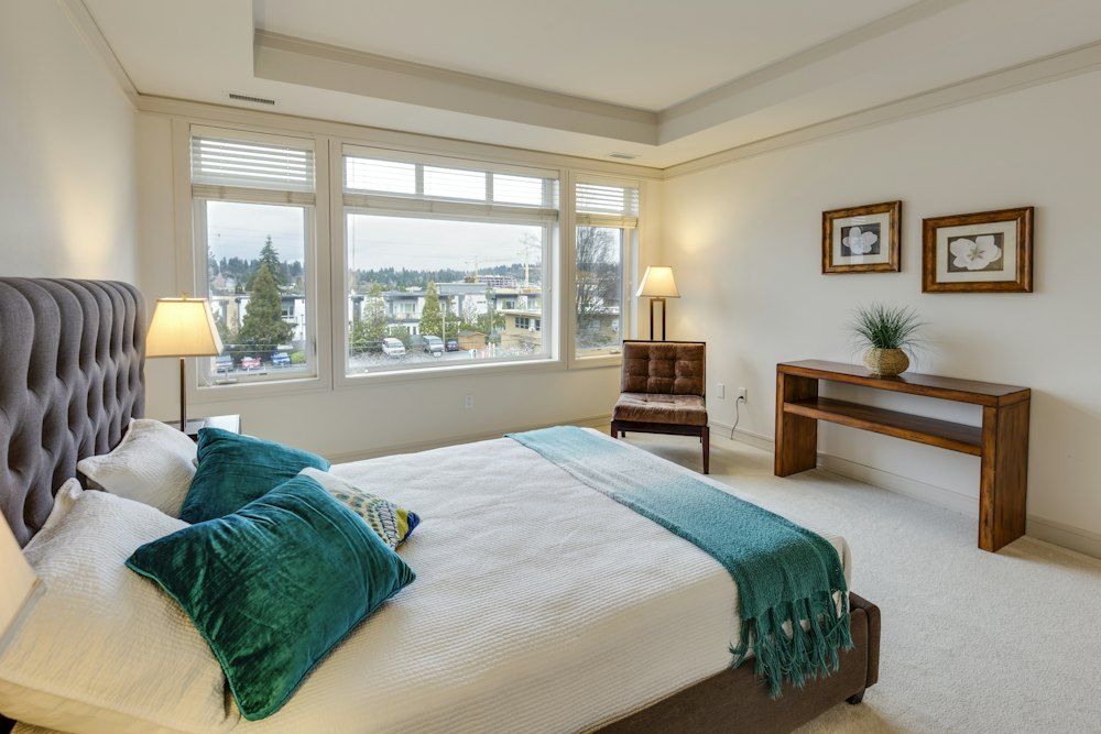 Two green and white pillows on empty bed