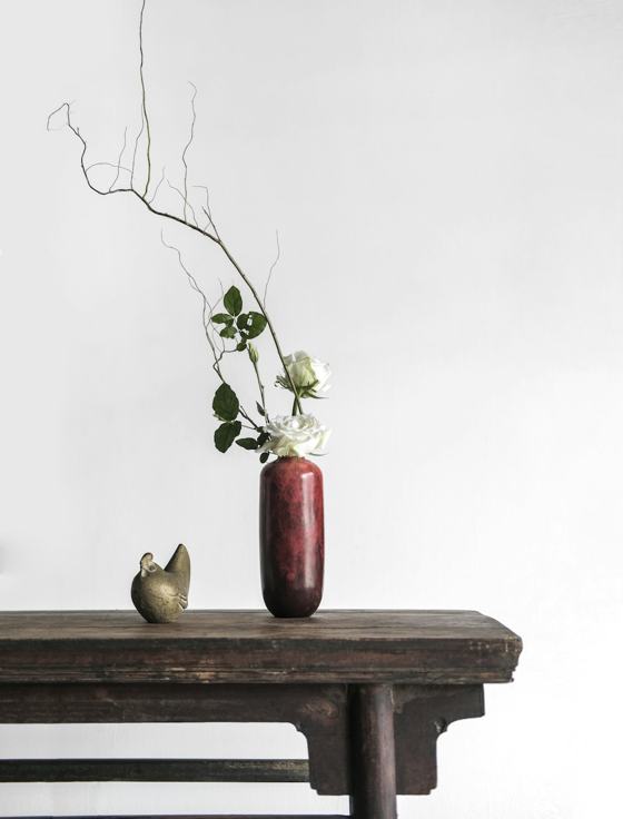 White roses in red ceramic vase