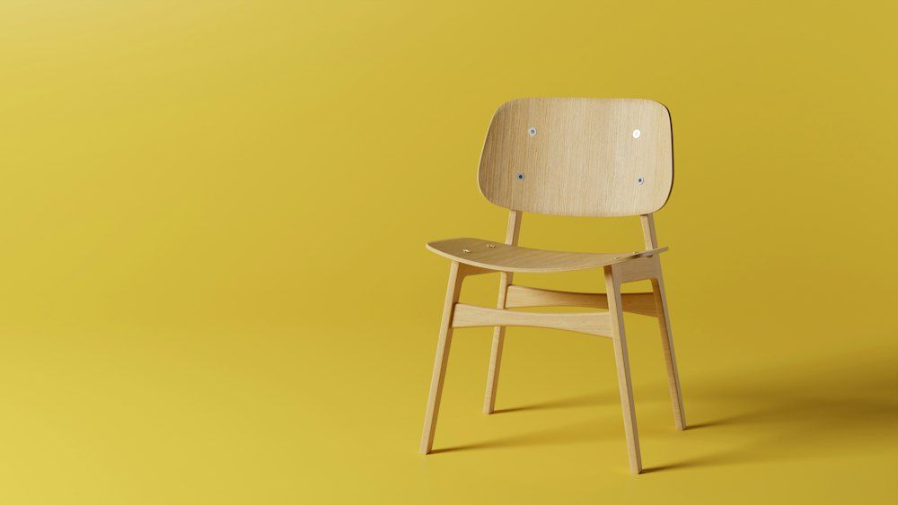 A wooden chair on a yellow background