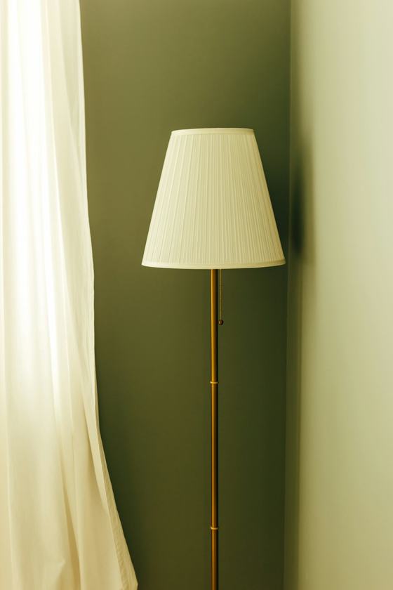 A tall floor lamp with a white shade