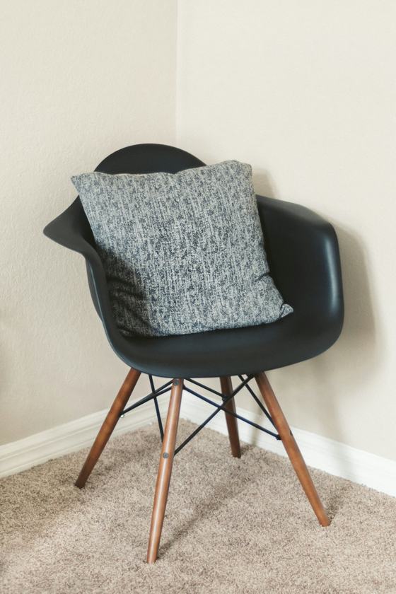Gray throw pillow on black leather chair