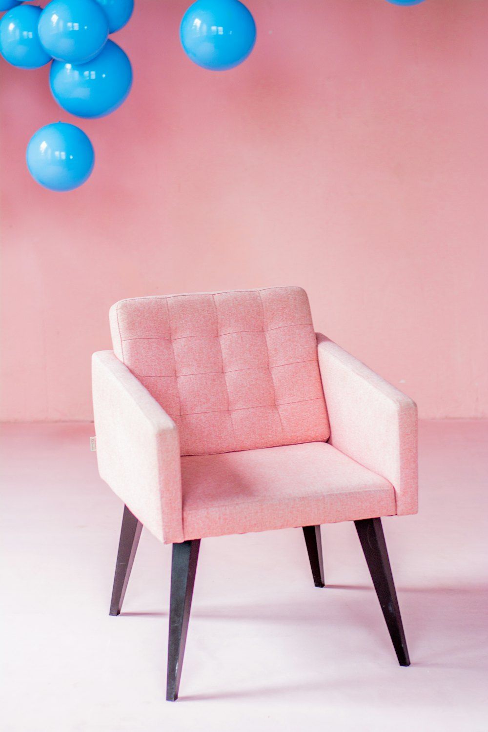 White padded armchair with black wooden frame