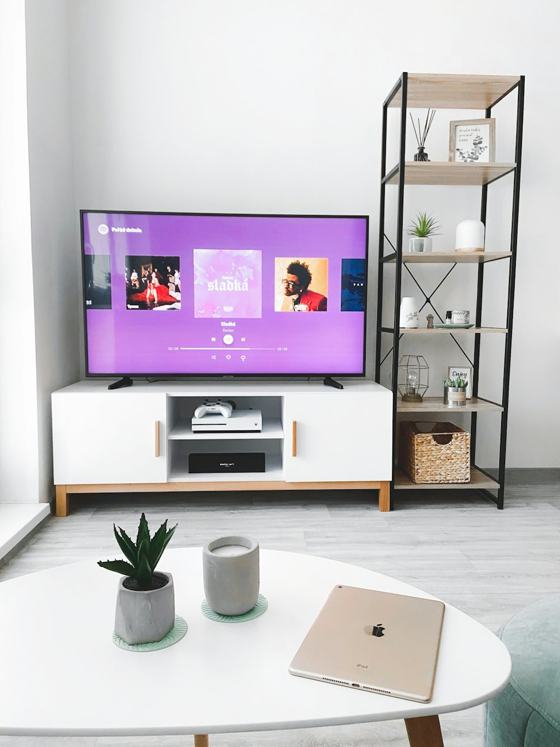 Black flat screen tv turned on displaying man in black suit