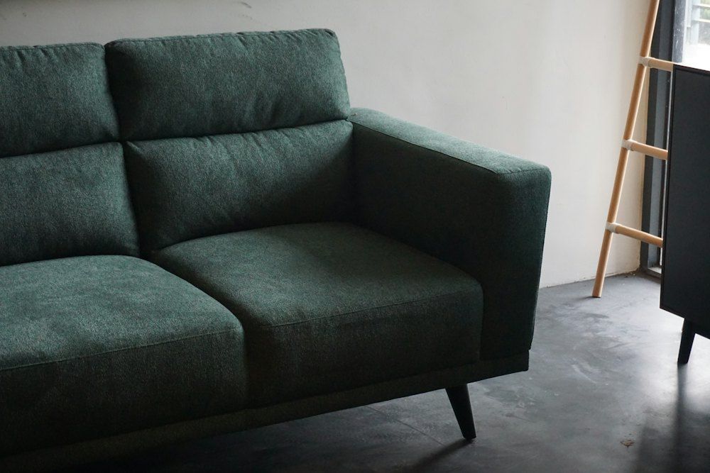 Gray cushion armchair beside white wall