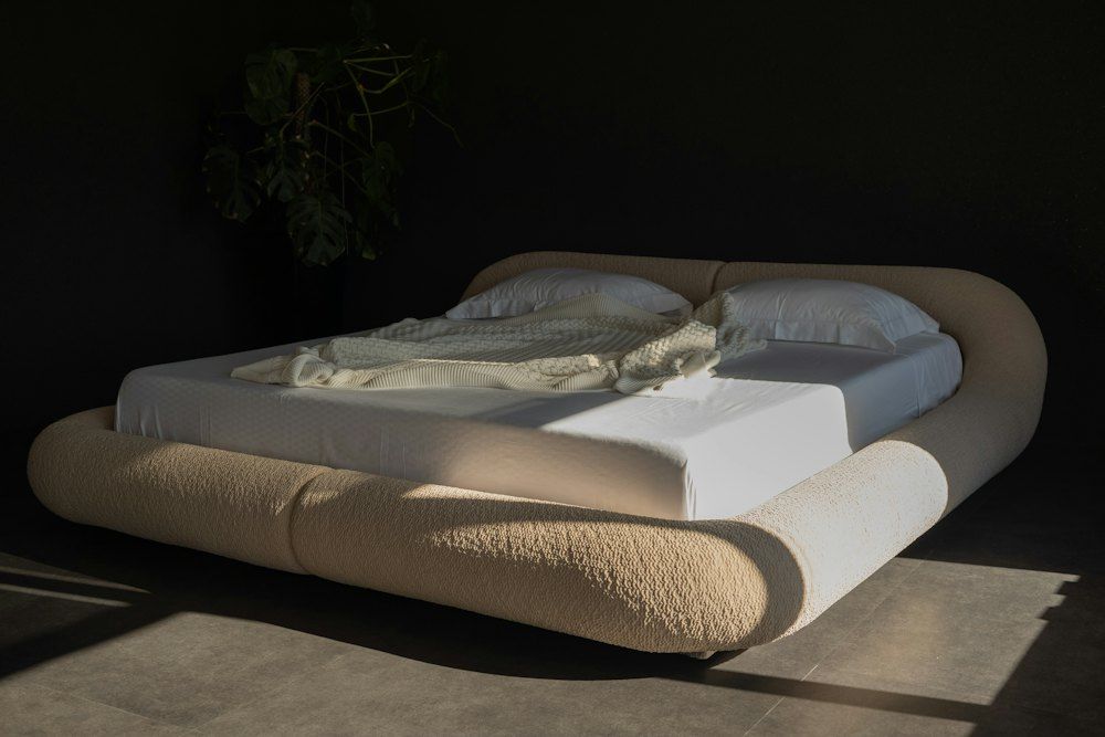 Modern bed with rounded headboard and white linens