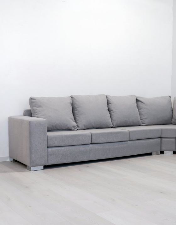 A modern grey sectional sofa against a white wall
