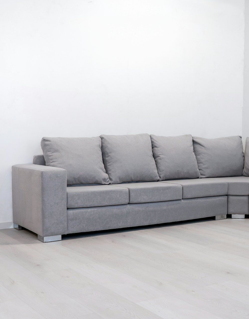 A modern grey sectional sofa against a white wall
