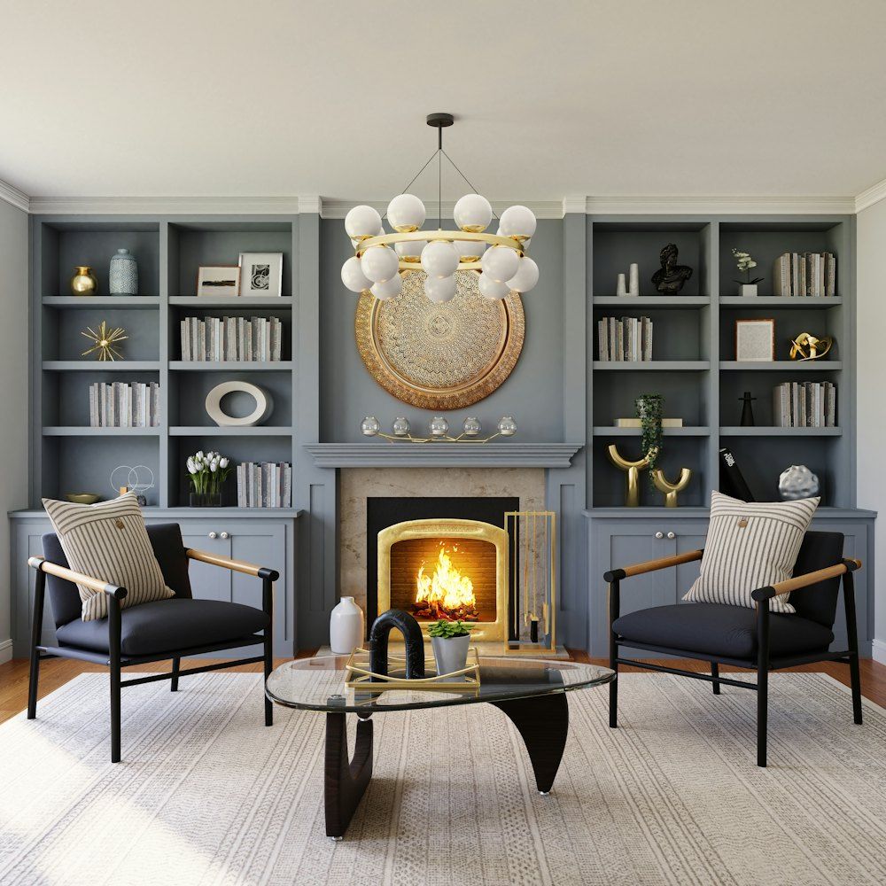 Two black armchairs facing a fireplace with a lit fire and built-in bookshelves