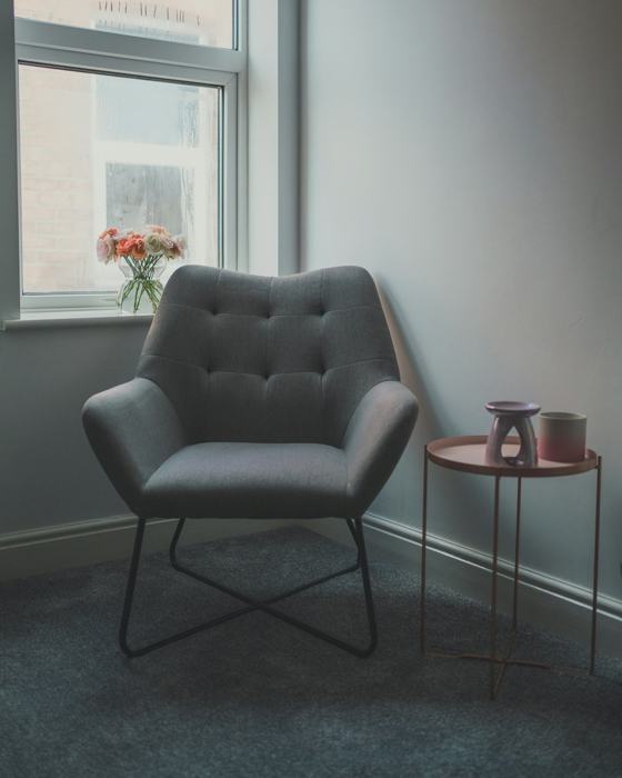 Gray sofa chair beside glass window