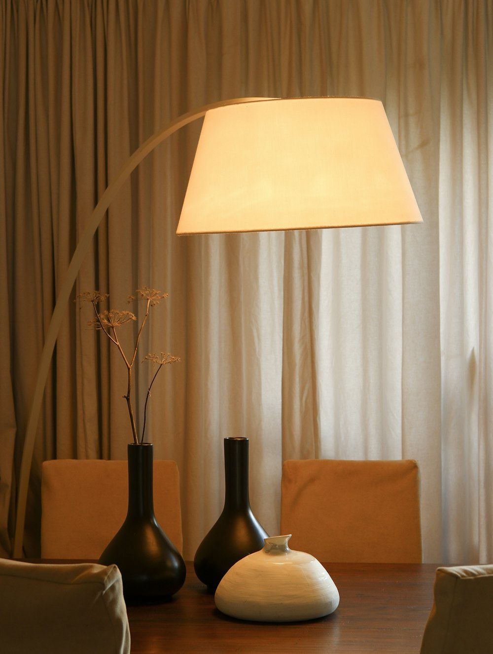 A table with two vases and a lamp on it