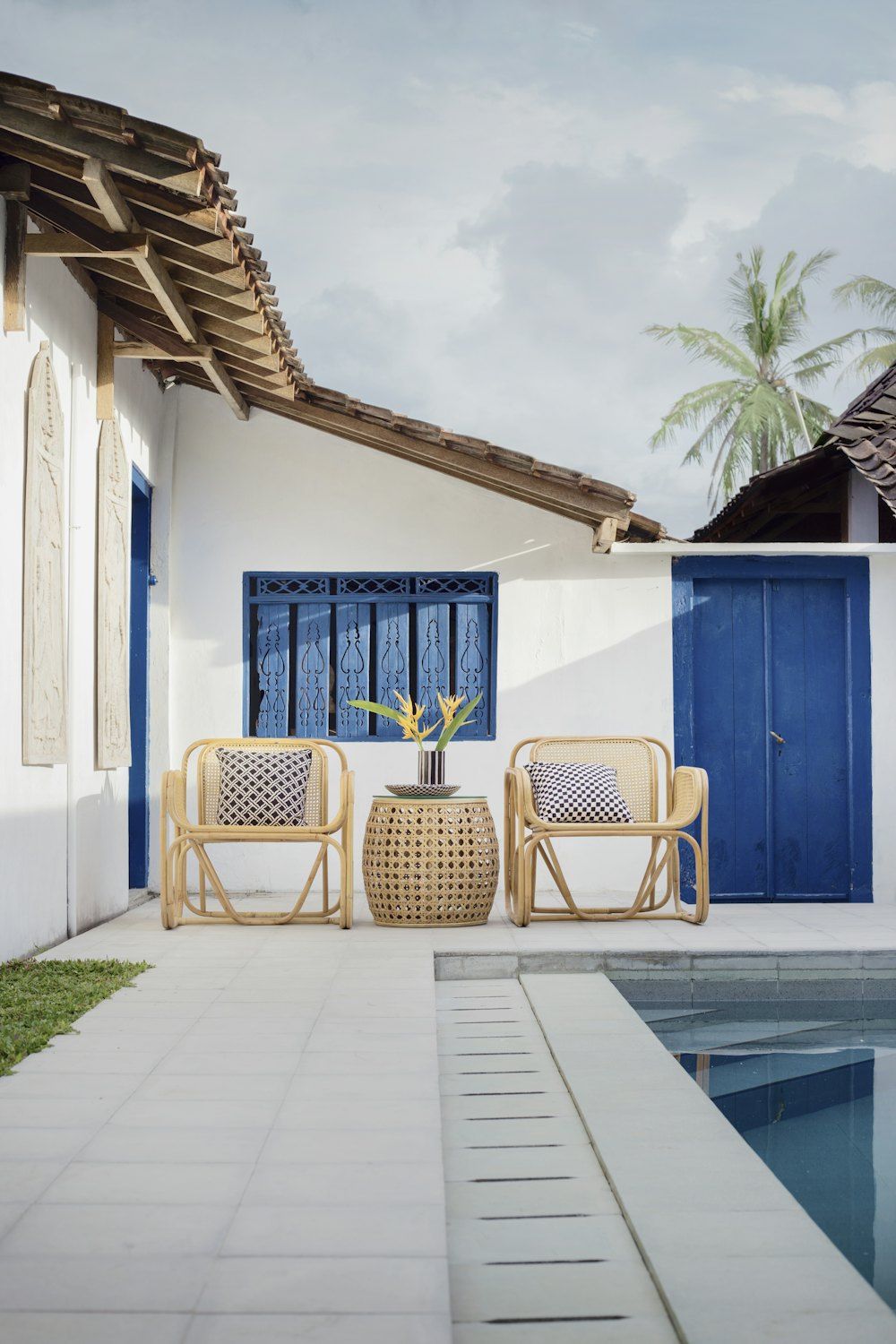 Wicker table and two chairs near swimming pool