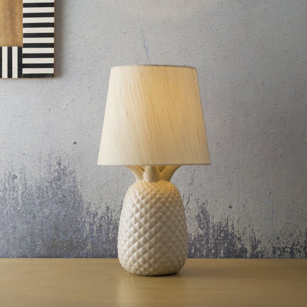 A white table lamp sitting on top of a wooden table