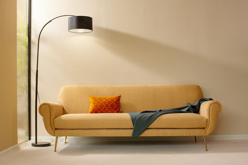 A living room with a couch and a lamp