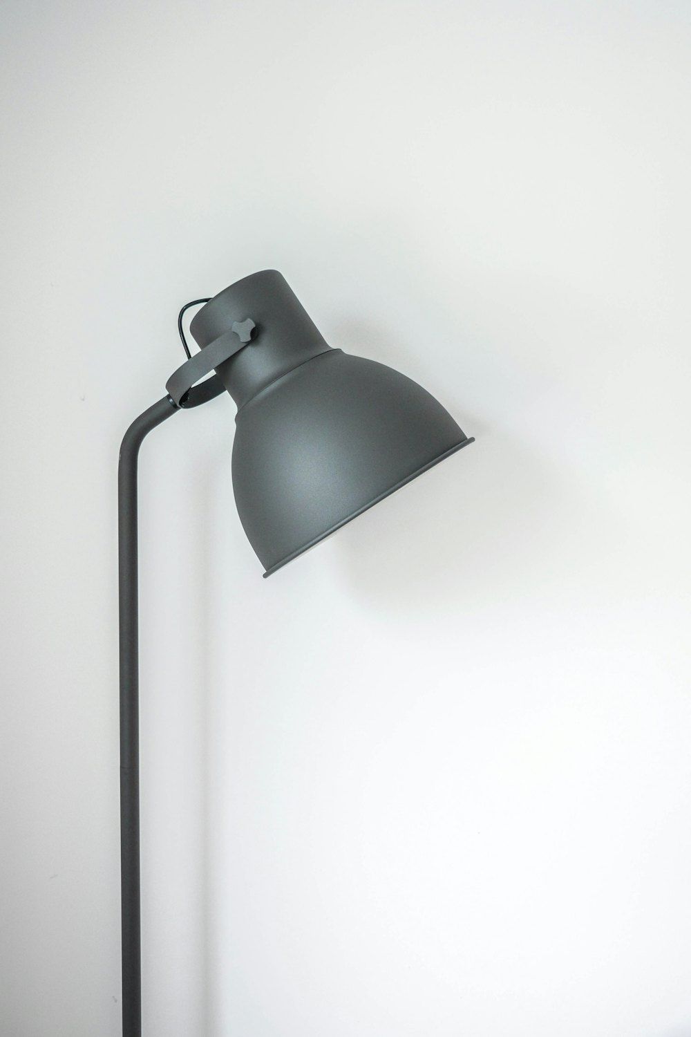 Gray desk lamp near white wall
