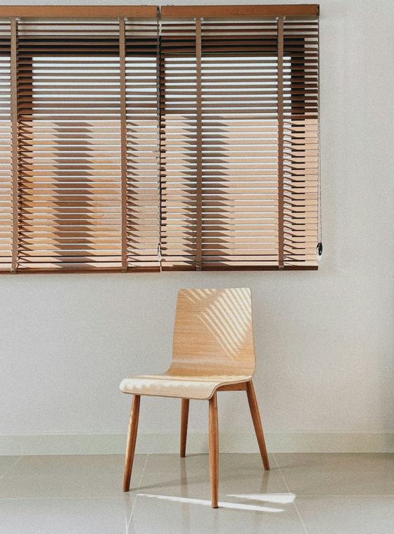 Brown wooden chair beside white wall