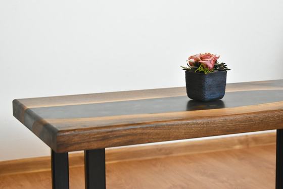 Red flower on blue ceramic vase on brown wooden table