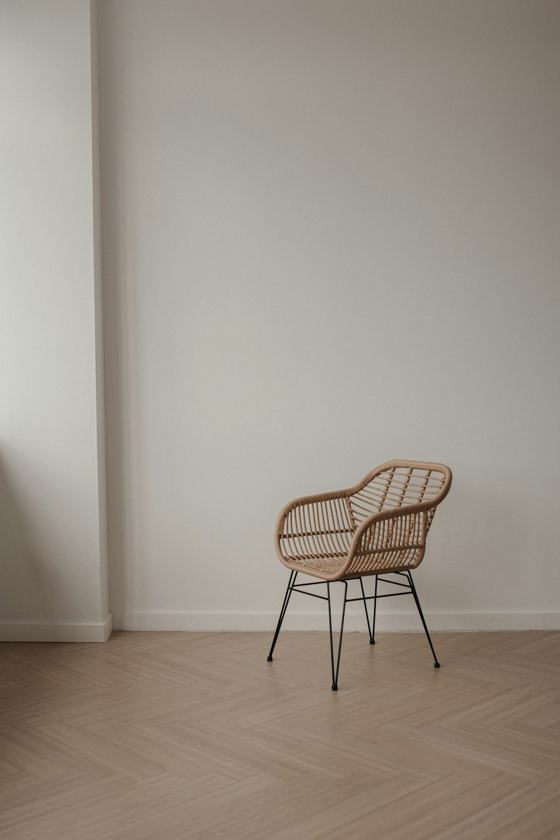 Wicker chair with metal legs on a wooden floor
