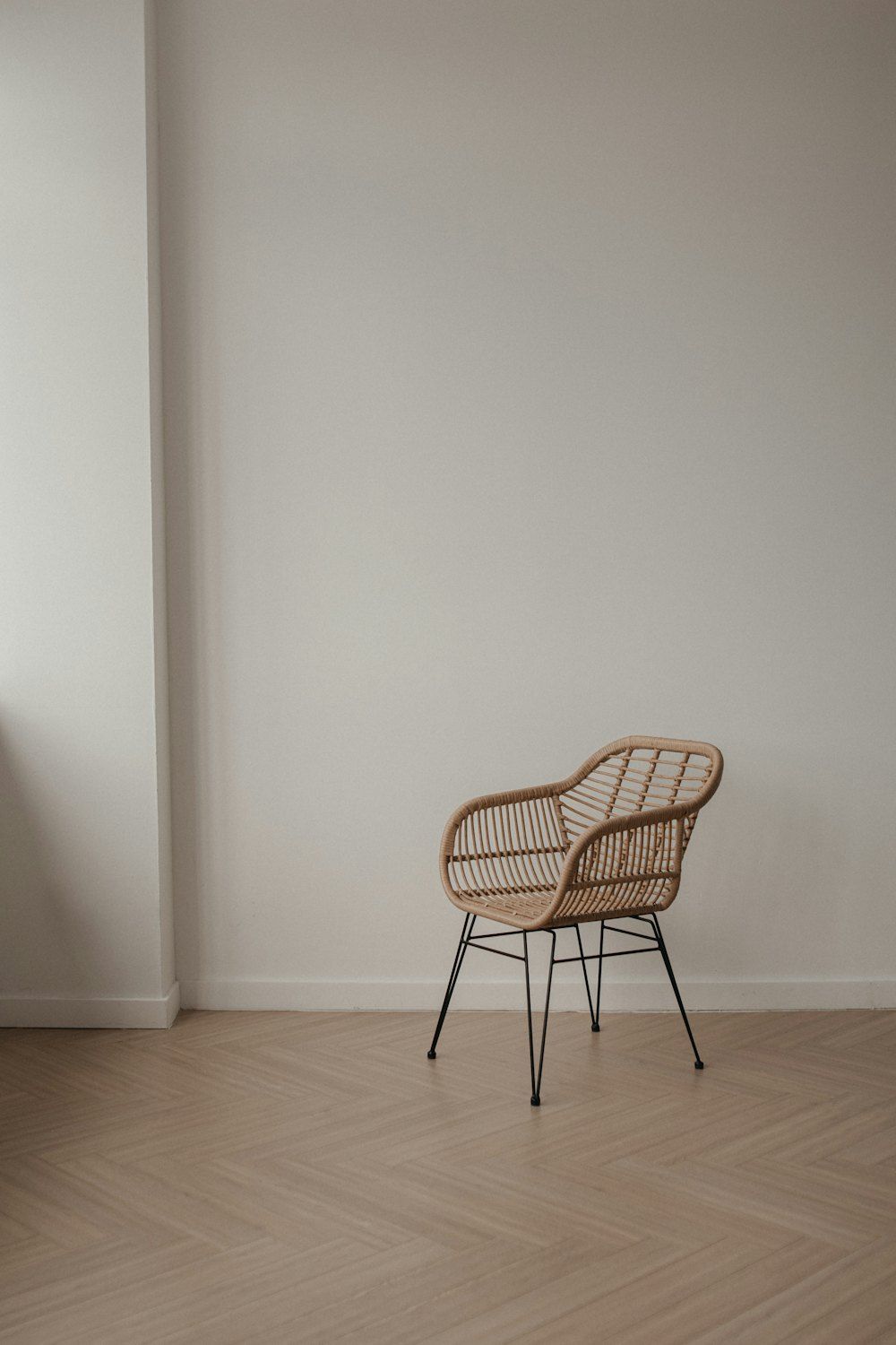 Wicker chair with metal legs on a wooden floor