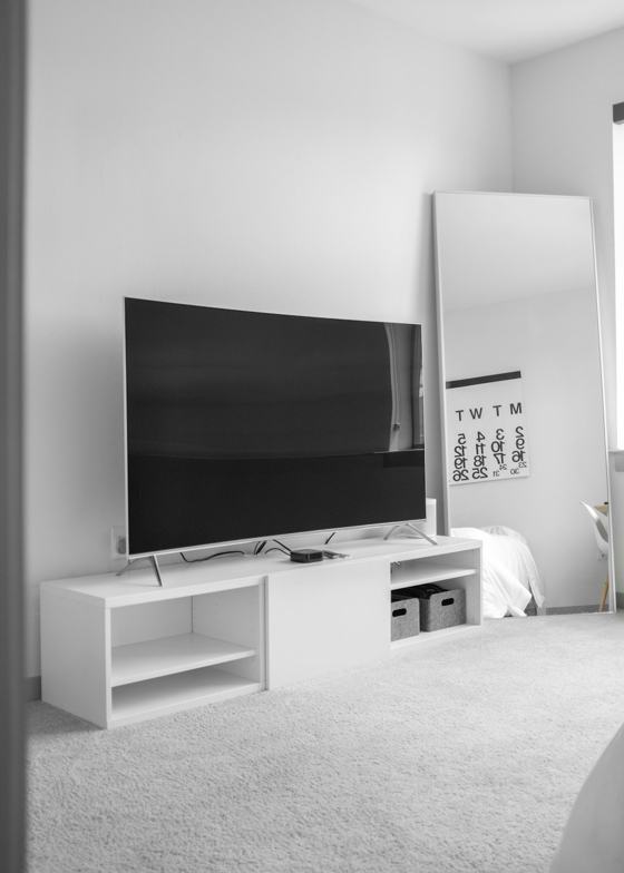 Gray flat screen TV on white TV stand