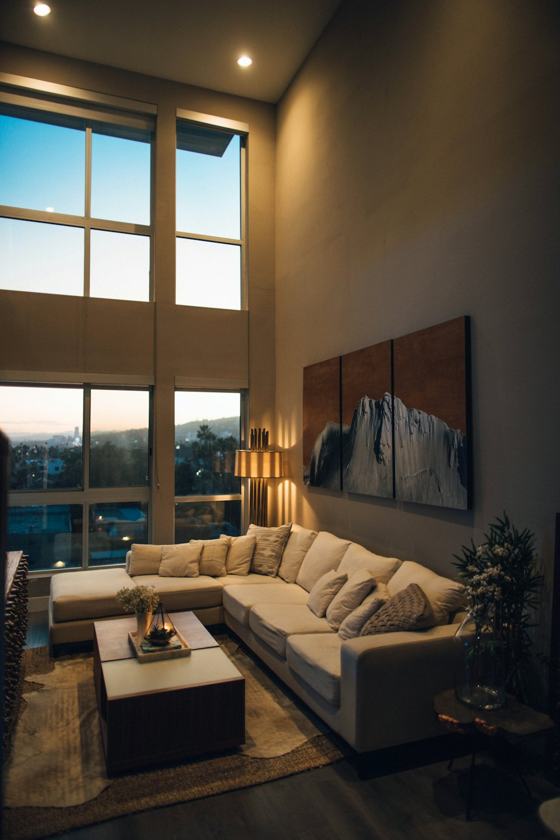 Gray padded chaise couch beside window