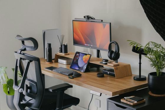 A wooden desk topped with a computer monitor and keyboard