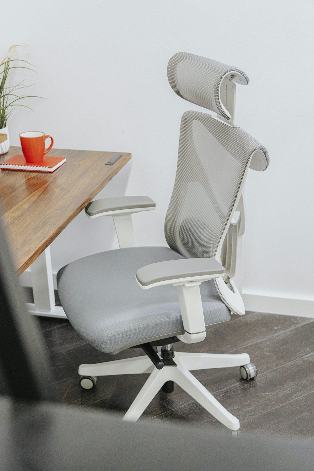 A gray office chair sitting next to a wooden table