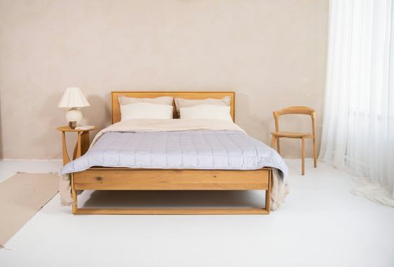 A bedroom with a bed and two chairs