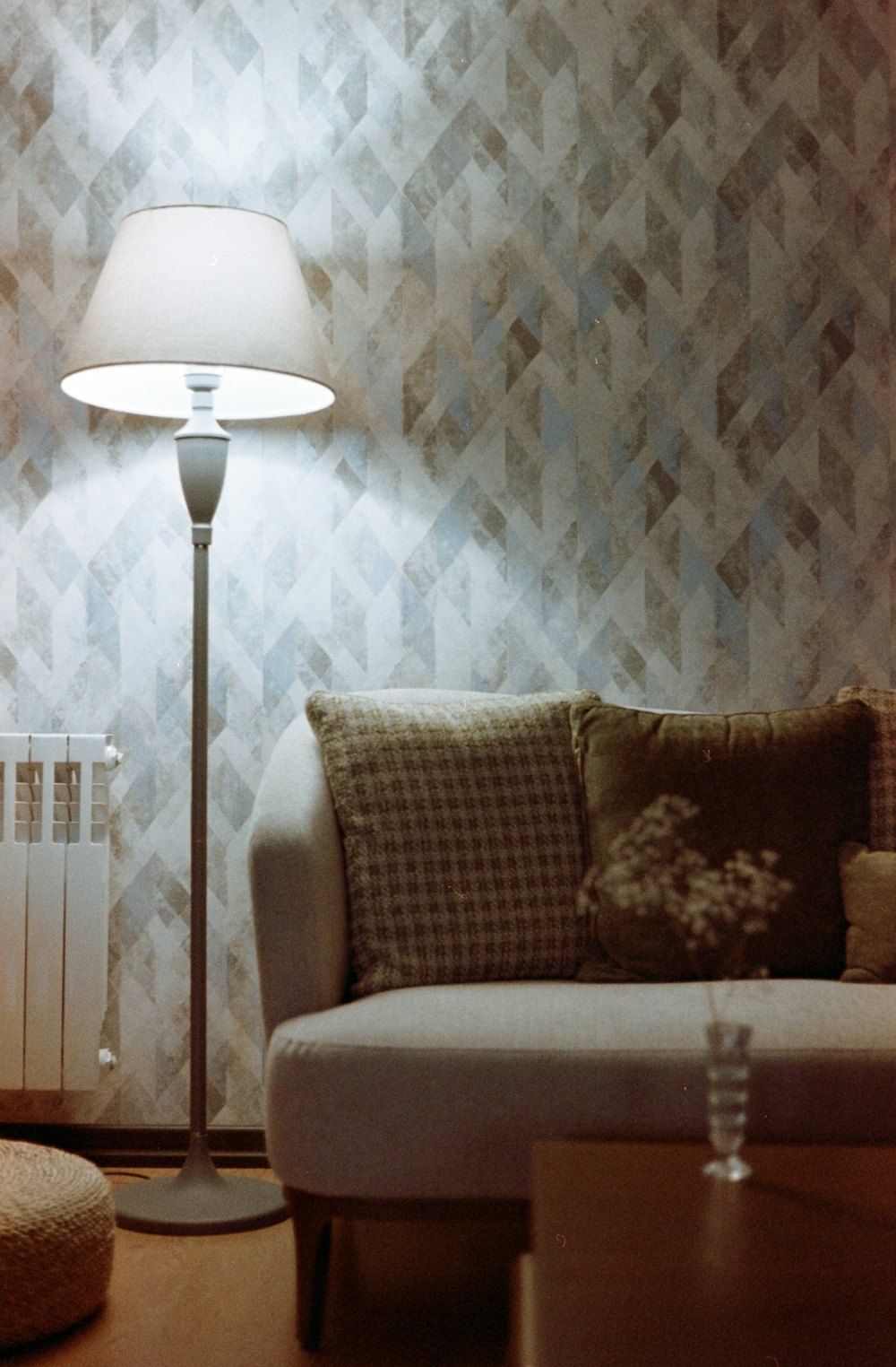 A living room with a couch and a lamp