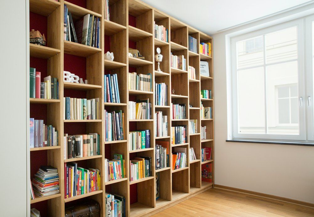 Brown wooden book shelves near window