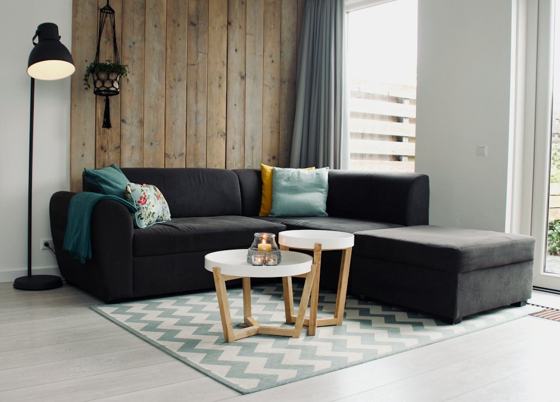 Light candle on round white coffee table and sectional sofa