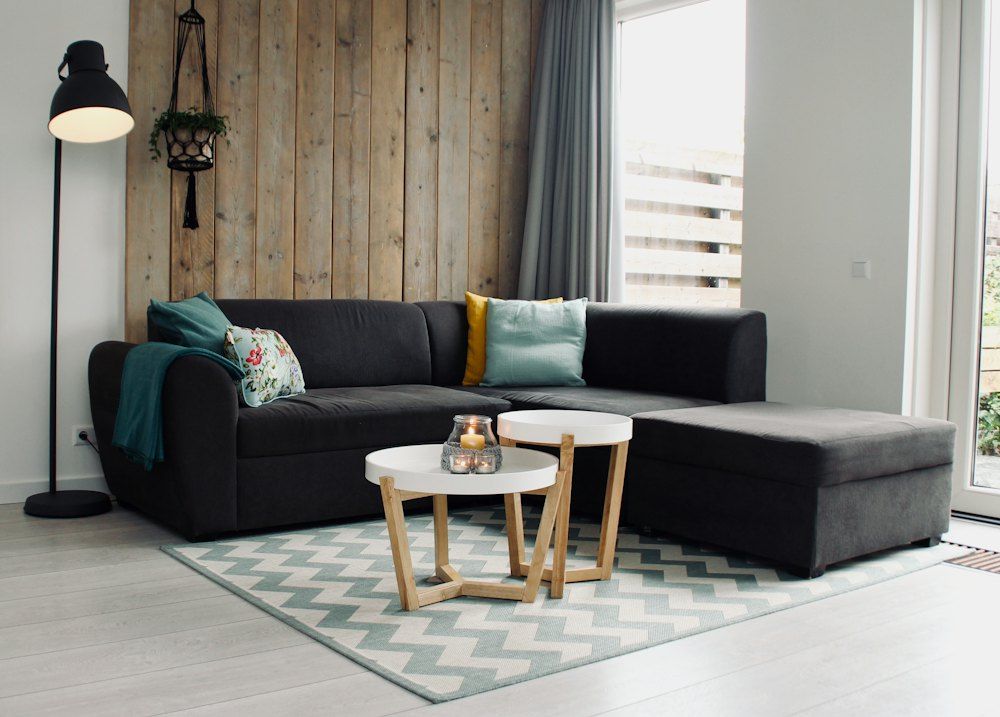Light candle on round white coffee table and sectional sofa