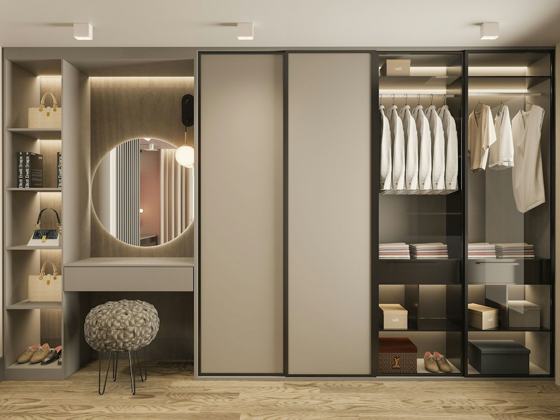 A walk in closet with a mirror and a stool