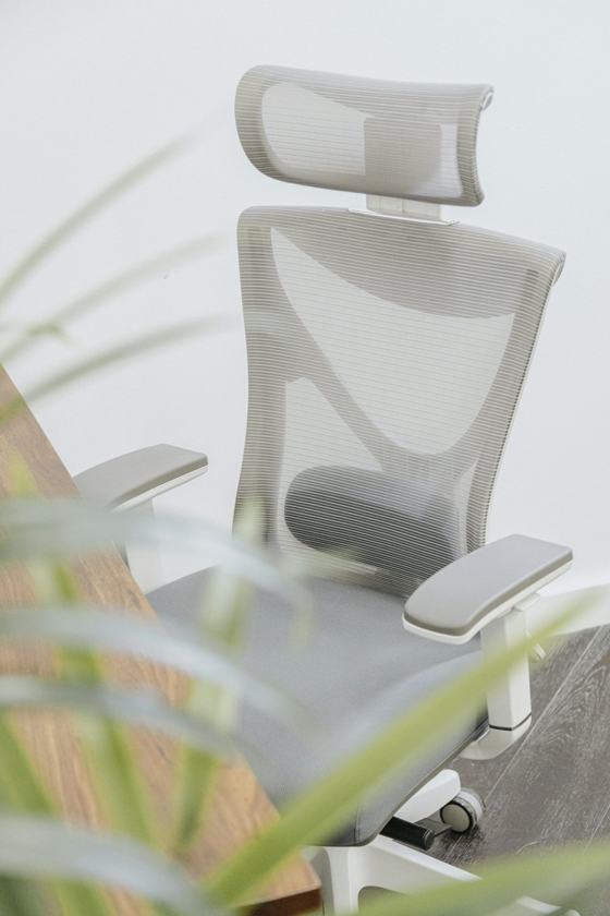 A white office chair sitting on top of a wooden desk