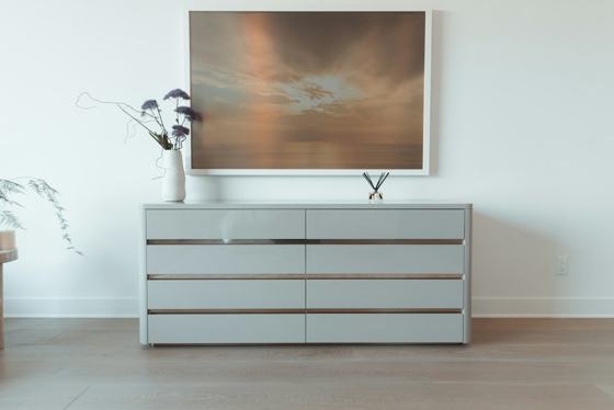 A picture hanging on a wall above a dresser