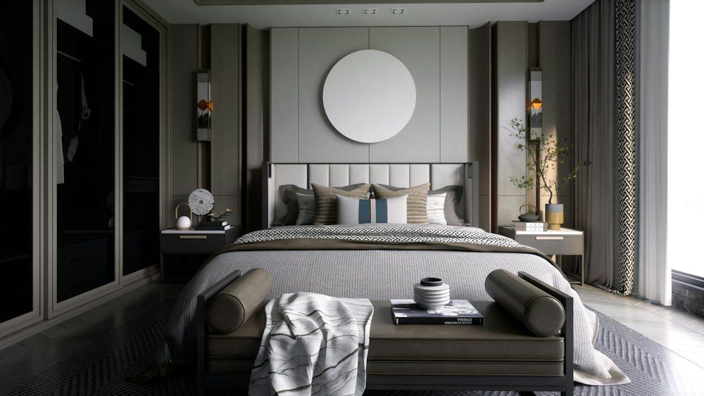 A bedroom with a large bed and a round mirror on the wall