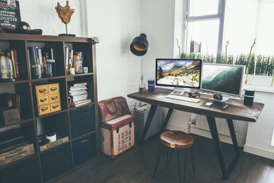Two flat screen monitor turned on near organizer rack inside the room