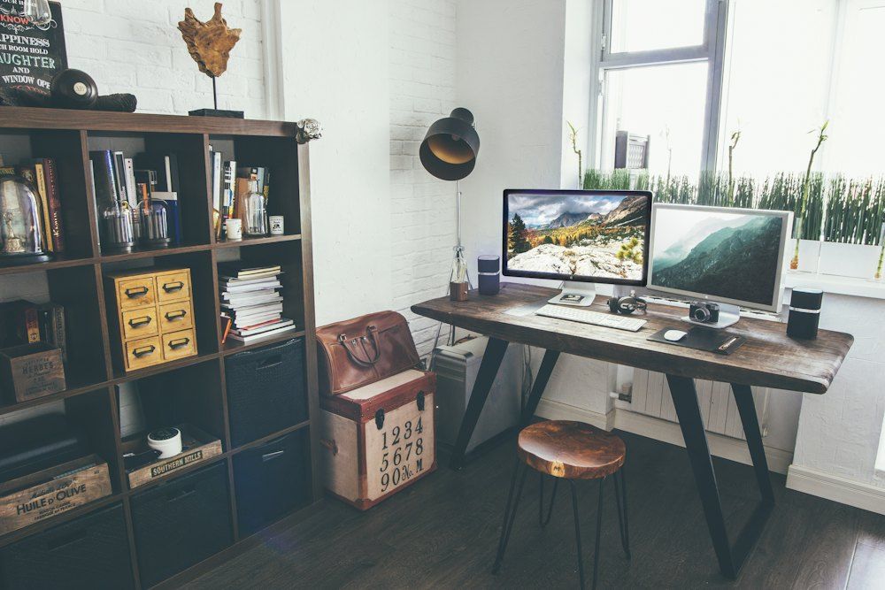 Two flat screen monitor turned on near organizer rack inside the room