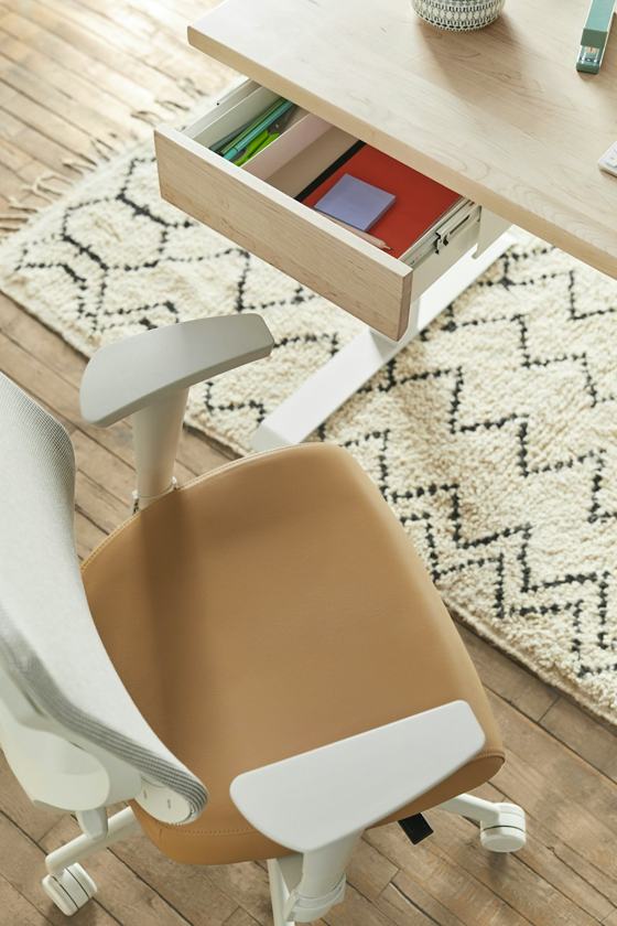 A desk with a chair and a drawer on top of it