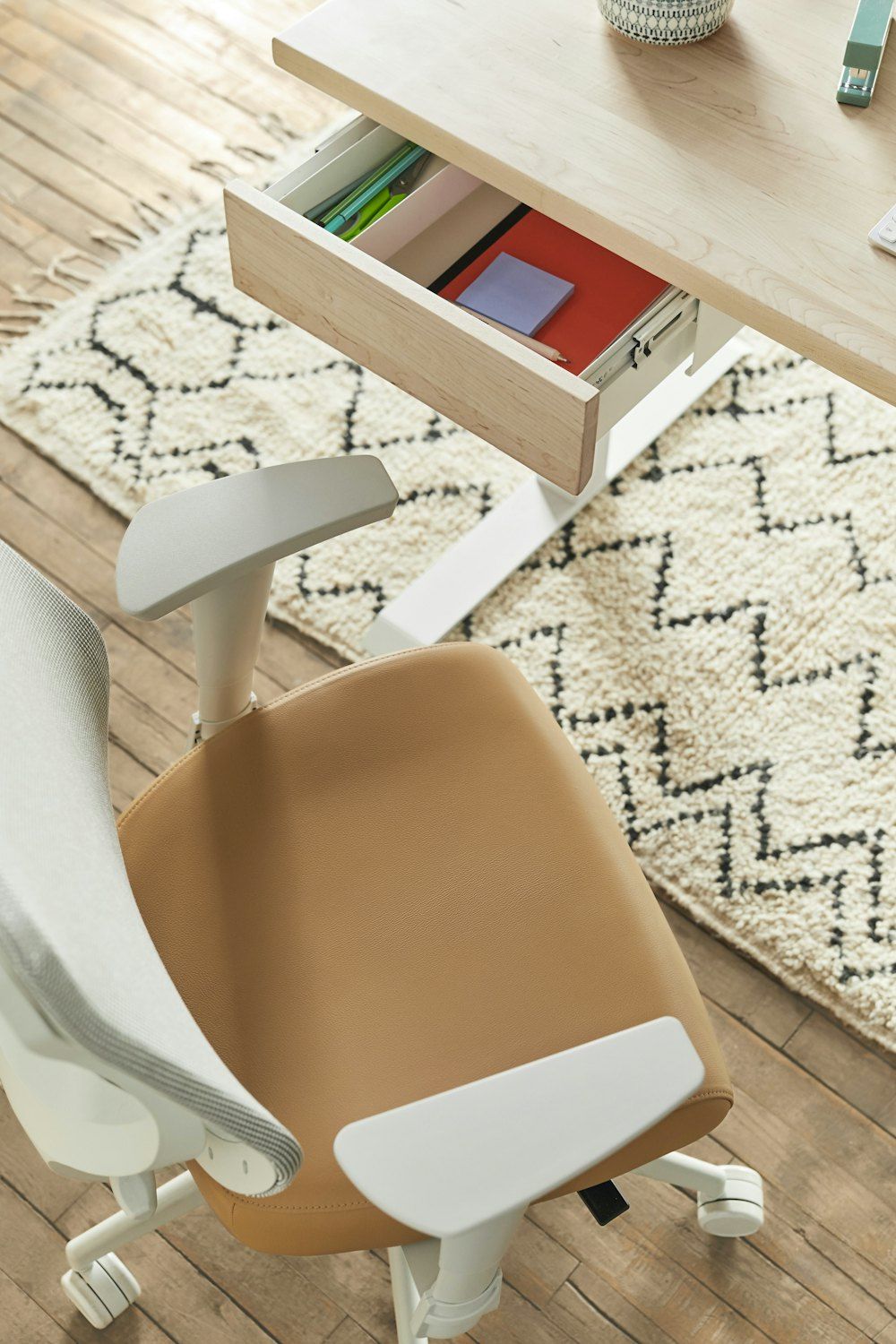 A desk with a chair and a drawer on top of it