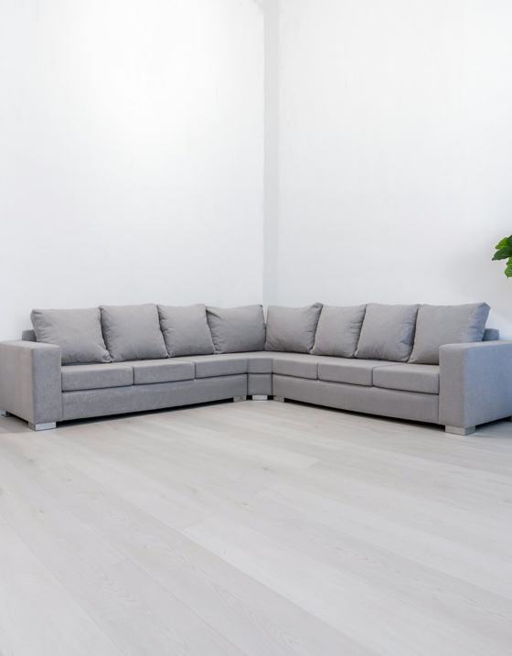 A modern gray sectional sofa in a minimalist room
